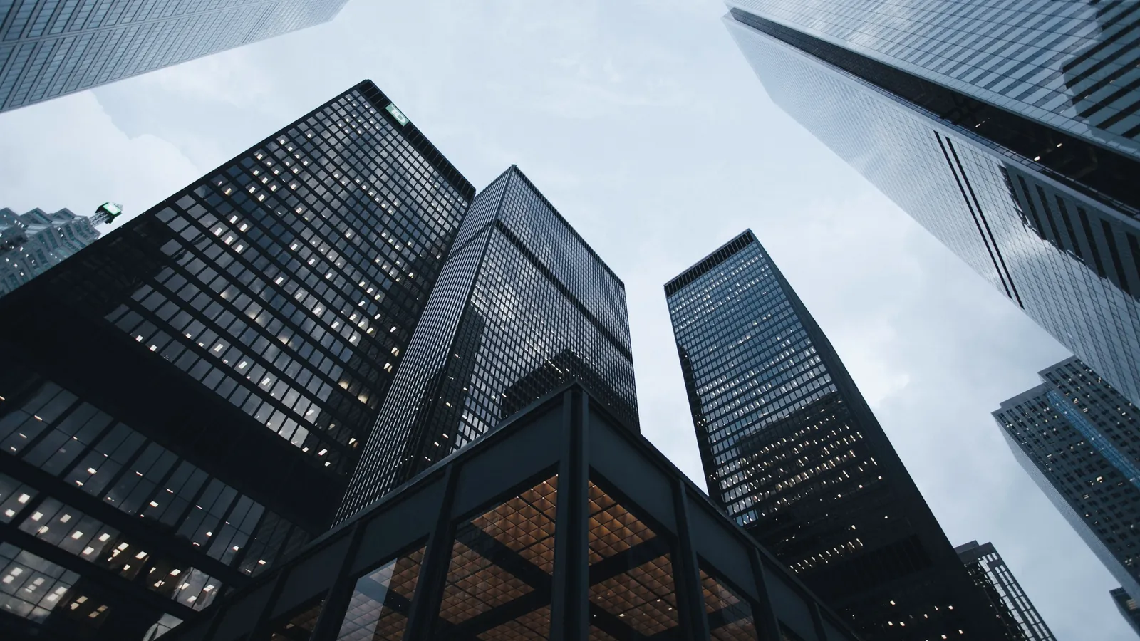 Glass office tower at dusk with scattered lit floors